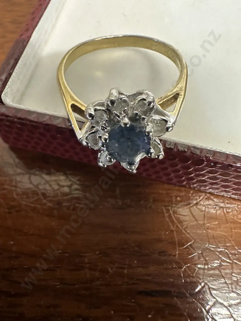 Gold Ring With large Blue Stone Surrounded By Smaller Clear Stones Image 1++