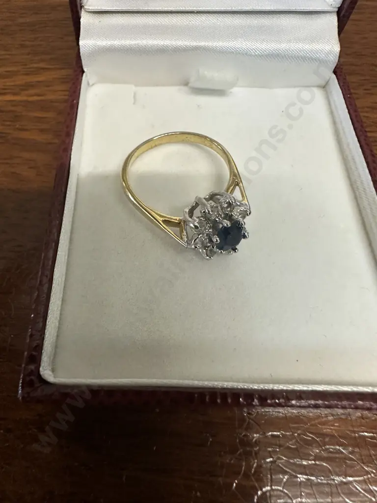 Gold Ring With large Blue Stone Surrounded By Smaller Clear Stones Image 1++