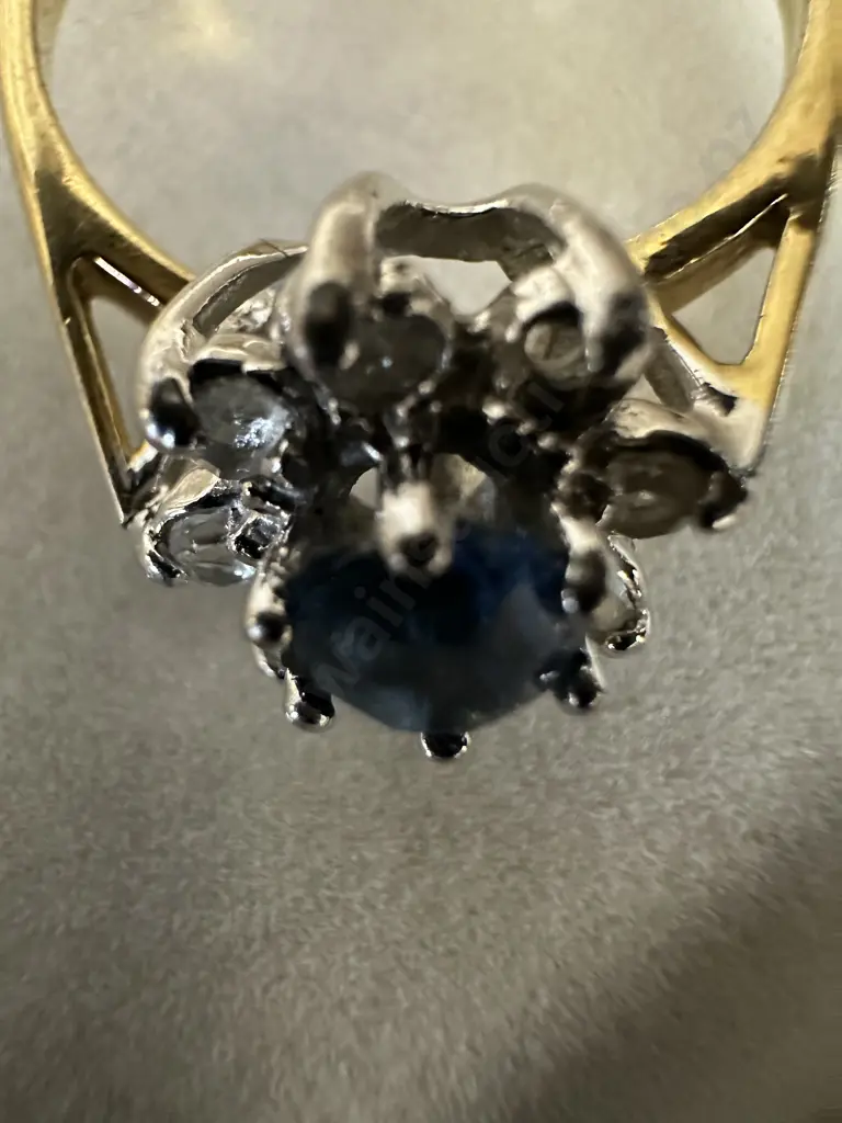 Gold Ring With large Blue Stone Surrounded By Smaller Clear Stones Image 1++