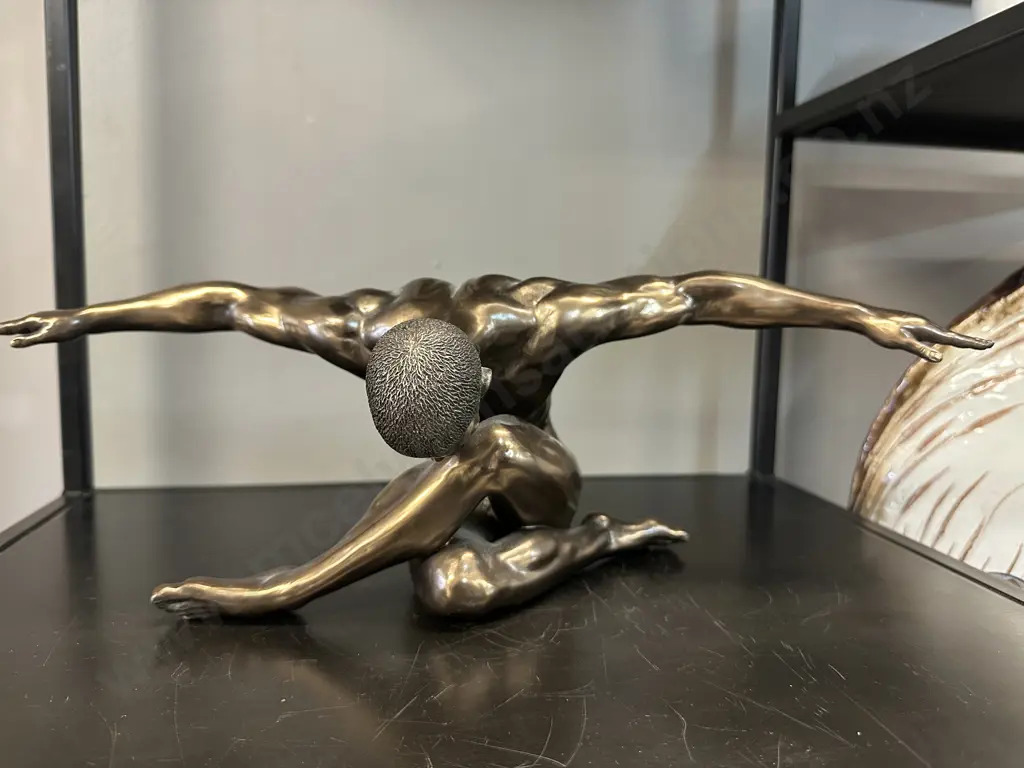 Bronze Coloured Sculpture Of A Male Figurine With Outstretched Arms Image 1++