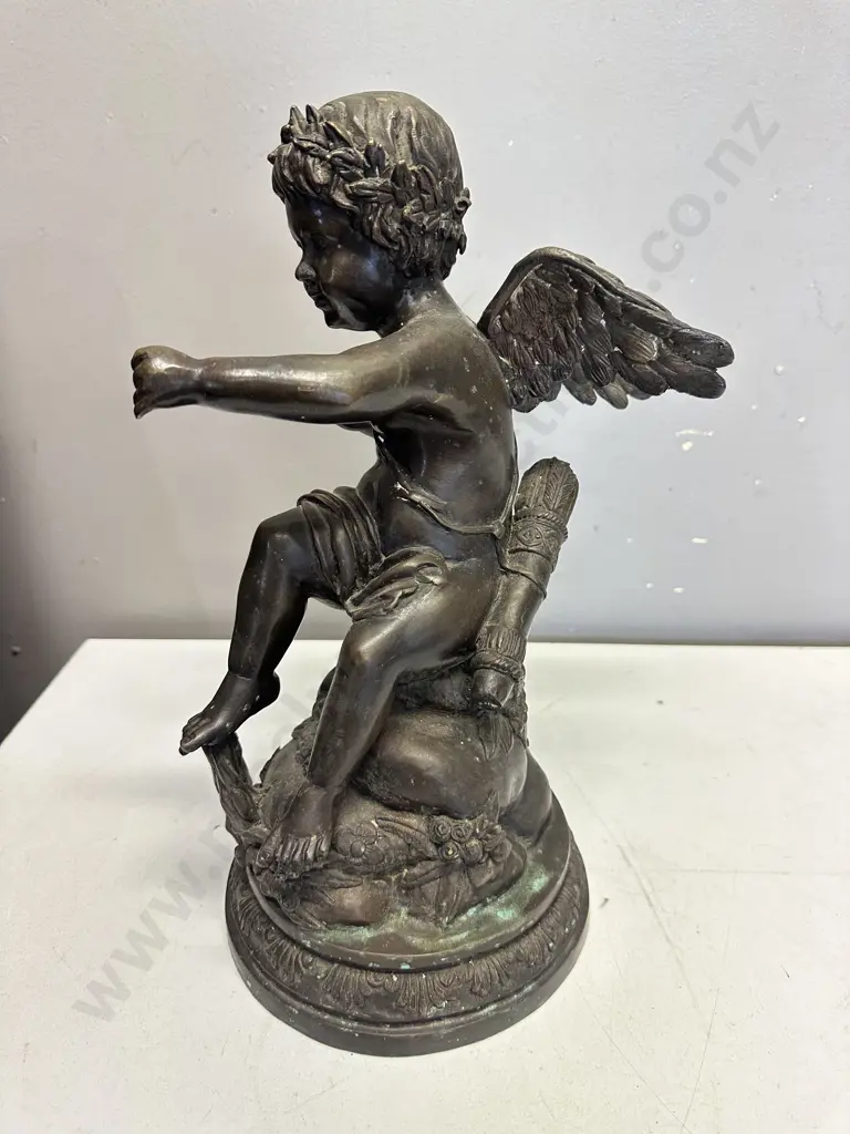 Spelter Sculpture Depicting A Winged Cupid Sitting On A Rock H33cm. Image 1++