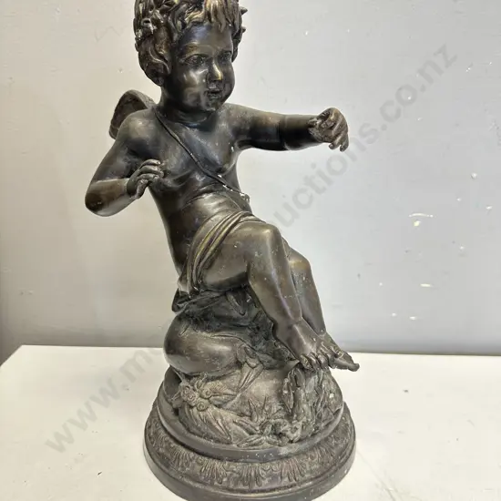 Spelter Sculpture Depicting A Winged Cupid Sitting On A Rock H33cm.
