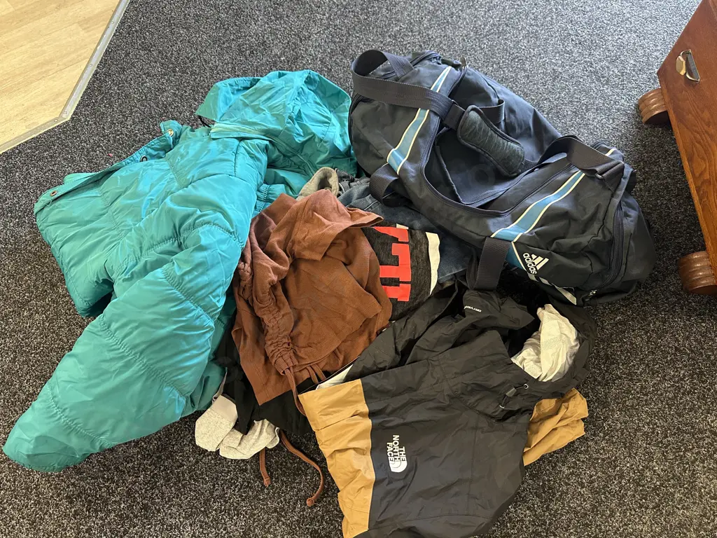 Green Puffer Jacket, North Face Jacket, Assorted Clothing & Blue Duffel Bag Image 1++